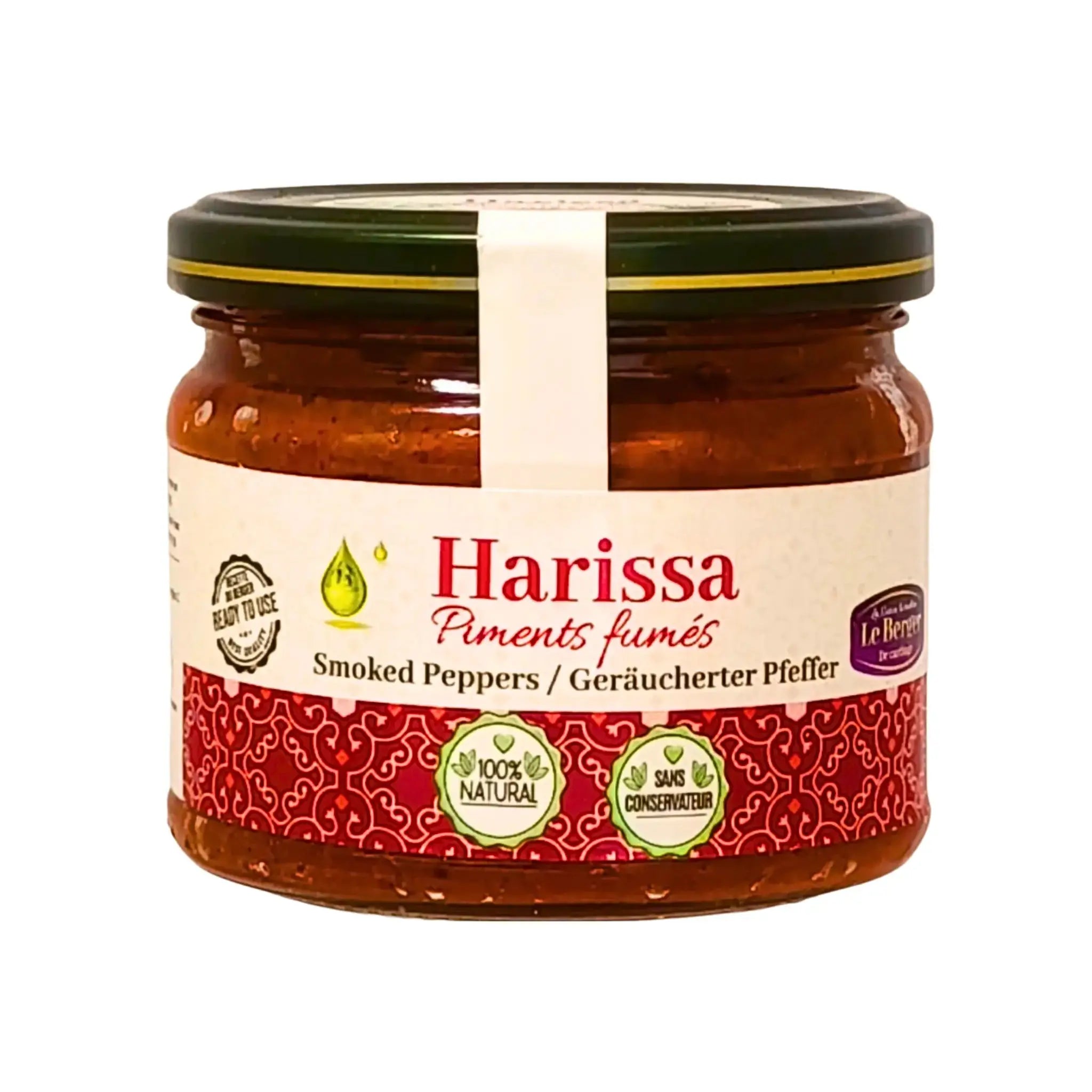 Glasburk med harissa av rökt paprika, orientaliskt kryddig chilisås, närbild på vit bakgrund.